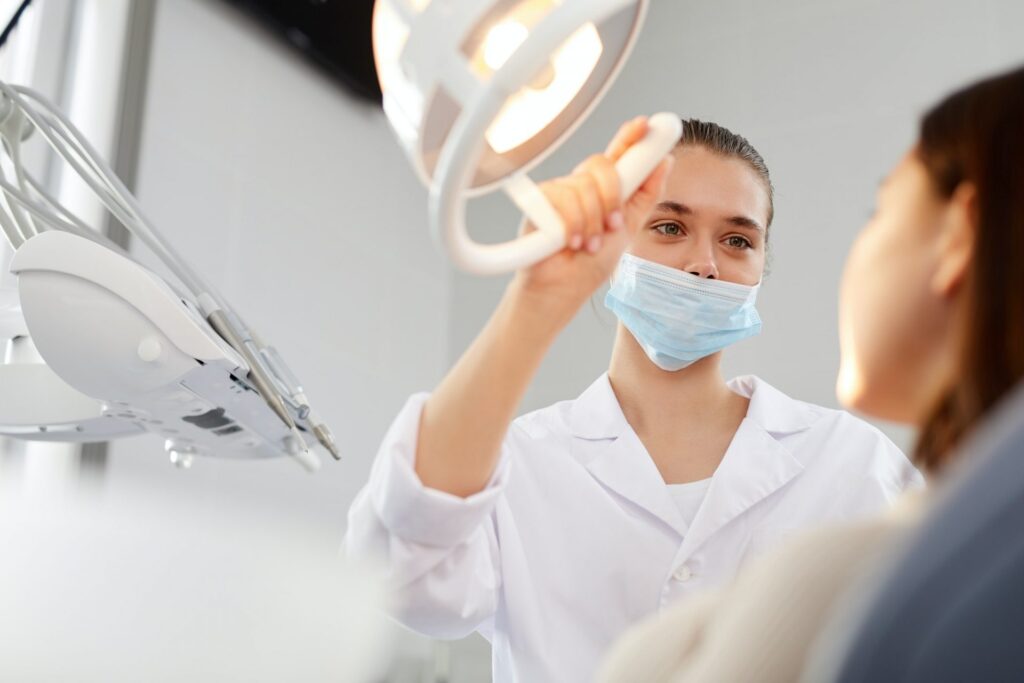 female-dentist-adjusting-lamp-e1617040195839